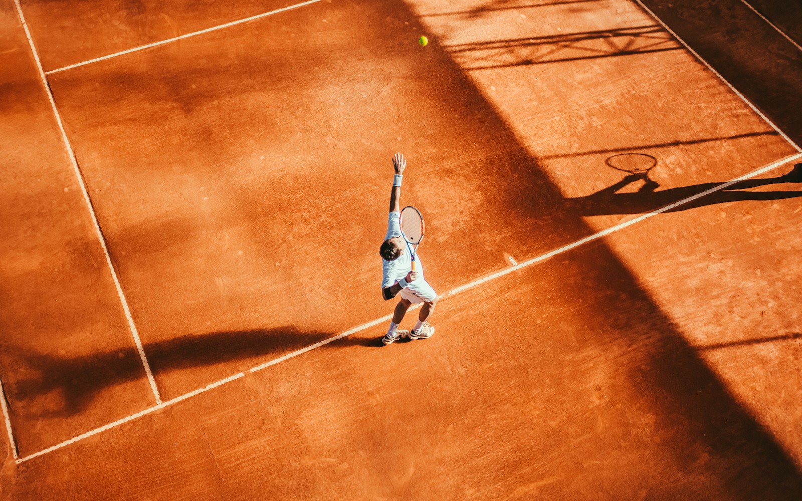 Joueur sur un court de tennis en terre battue, photographie d’illustration sans lien avec le tournoi cité.